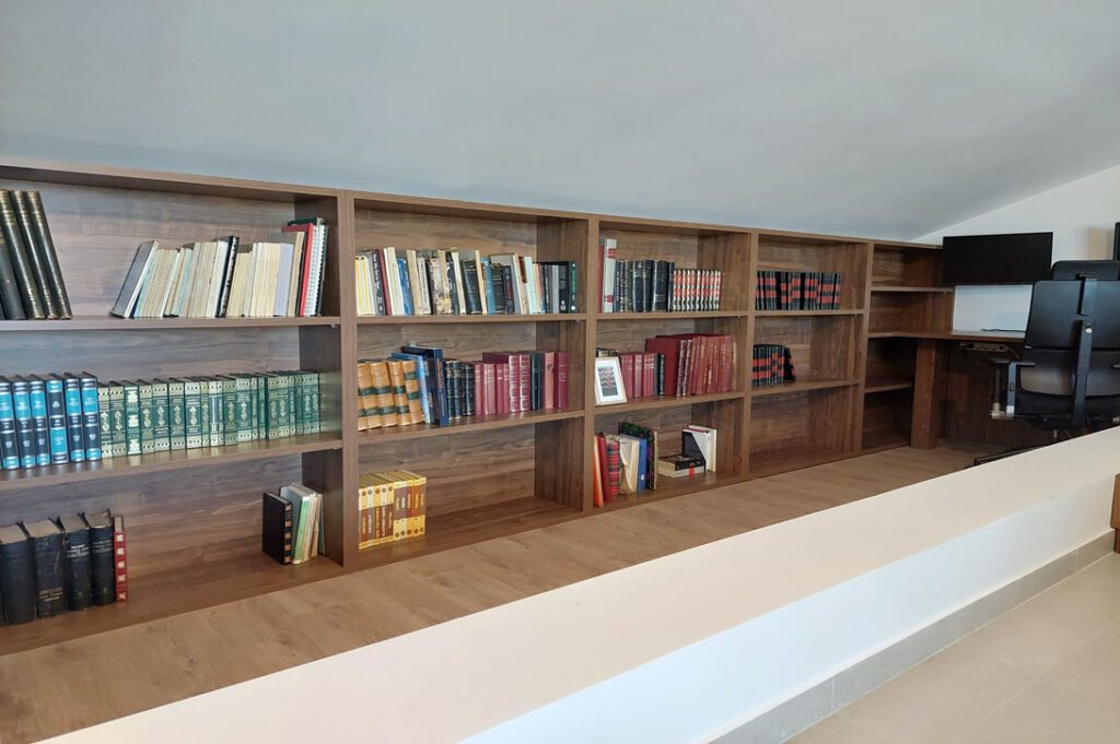 Ειδική κατασκευή βιβλιοθήκης από ξύλο καρυδιάς σε όλο τον τοίχο — Miacasa